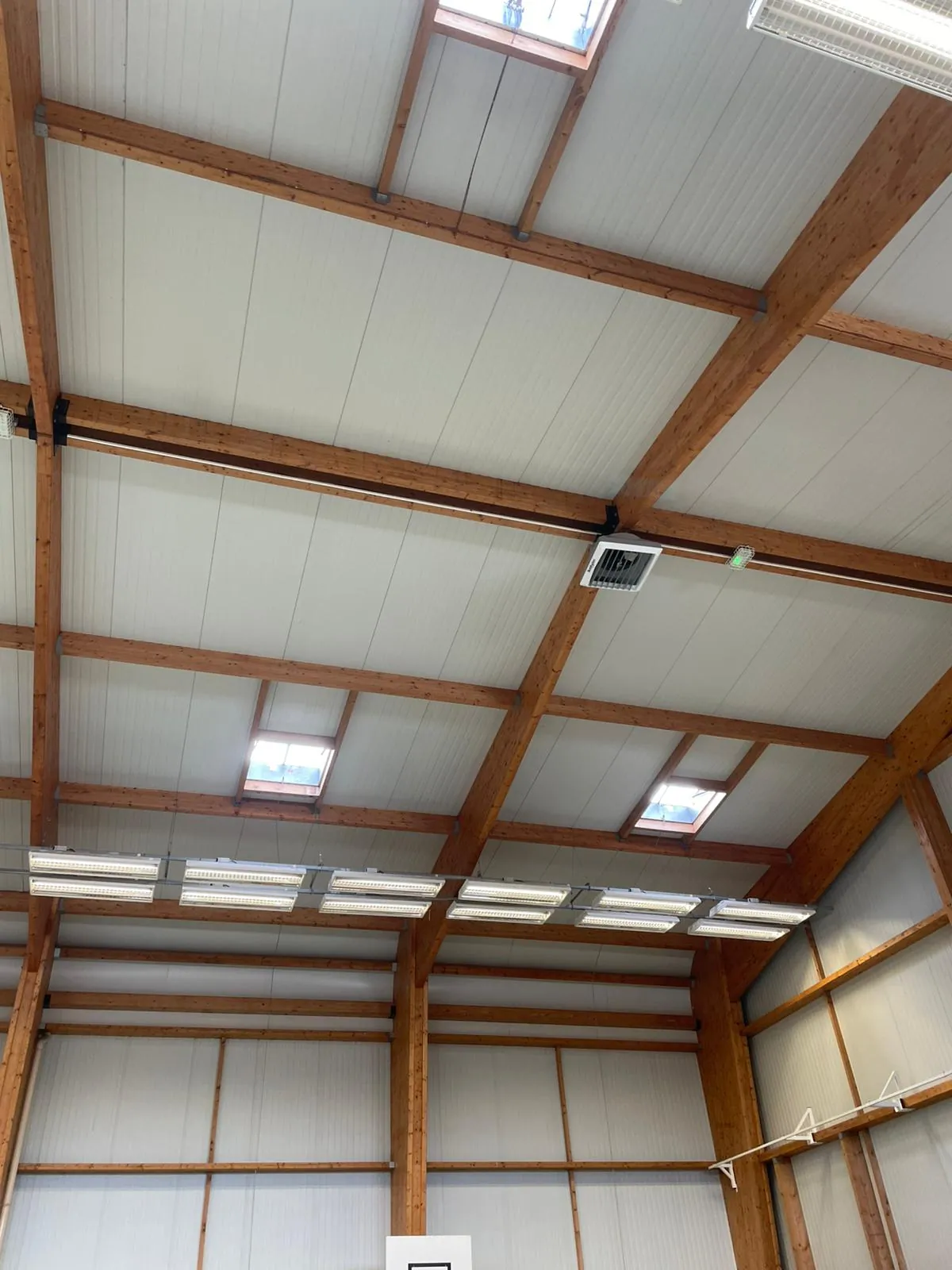 Hall industriel avec déstratificateurs d'air suspendus à la charpente